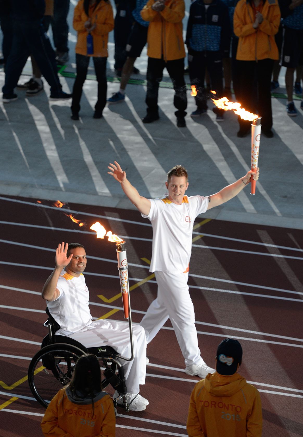 Steve Daniel and Dominic Larocque carry the flame into the stadium