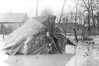 Un Canadien découvre sa tente et son abri dans l'eau, Avril 1917.