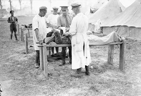 Major McGill and assistants, 5th Canadian Field Ambulance, dressing wounded outdoors, Battle of Amiens. Photo: Library and Archives Canada/PA-002890
