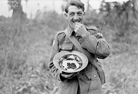 A Canadian enjoying blackberries which he had just gathered in Bourlon Wood.  Advance East of Arras.  October, 1918. Photo: Library and Archives Canada/PA-003419
