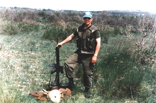 Mark Isfeld tenant le canon de son arme à feu avec le manche au sol.