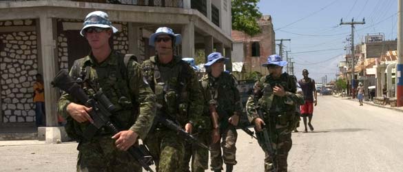 Des gardiens de la paix canadiens et argentins en patrouille pédestre à Gonaïves en Haïti.