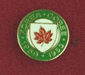 Insigne de service en Corée.  Une médaille circulaire 3/4 pouce (19 mm>) de diamètre. Il est chargé en son centre d'un écu crème à la feuille d'érable rouge. Le pourtour du cercle, vert.