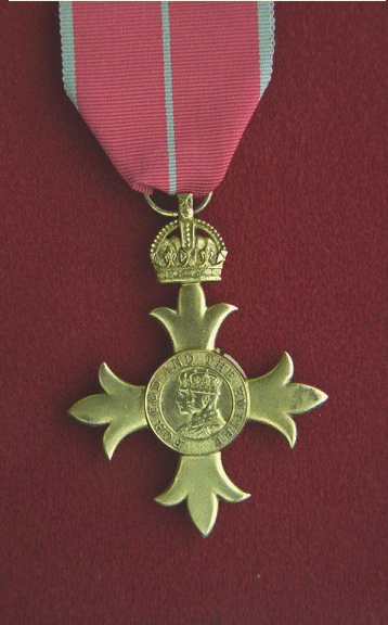 Officer of the Order of the British Empire.  The silver-gilt badge (2 inches wide) is gold in appearance with no enamels and is worn on the left breast.