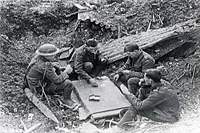 Canadiens jouant aux cartes dans un cratère d'obus sur la crête de Vimy.