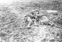 Un Canadien et un Allemand blessés allument une cigarette dans la boue, 1917.