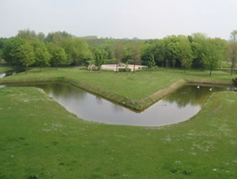 Îlot artificiel en forme de feuille d&#039;érable avec des érables en arrière plan.